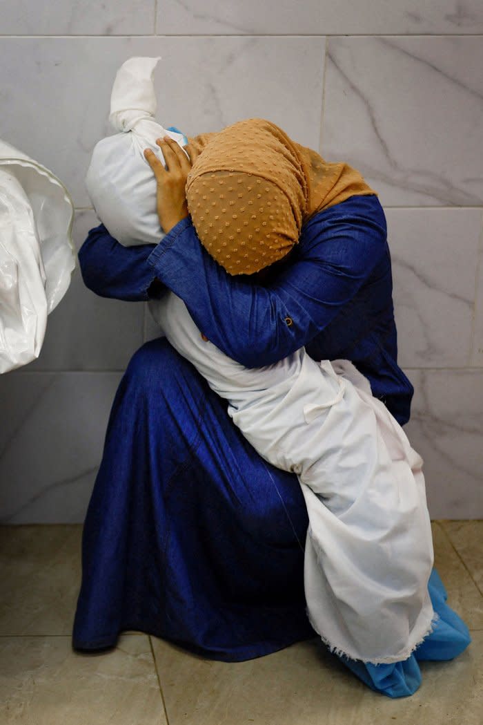 Palestinian woman Inas Abu Maamar, 36, embraces the body of her 5-year-old niece Saly, who was killed in an Israeli strike, at Nasser hospital in Khan Younis in the southern Gaza Strip, Oct. 17.<span class="copyright">Mohammed Salem—Reuters</span>