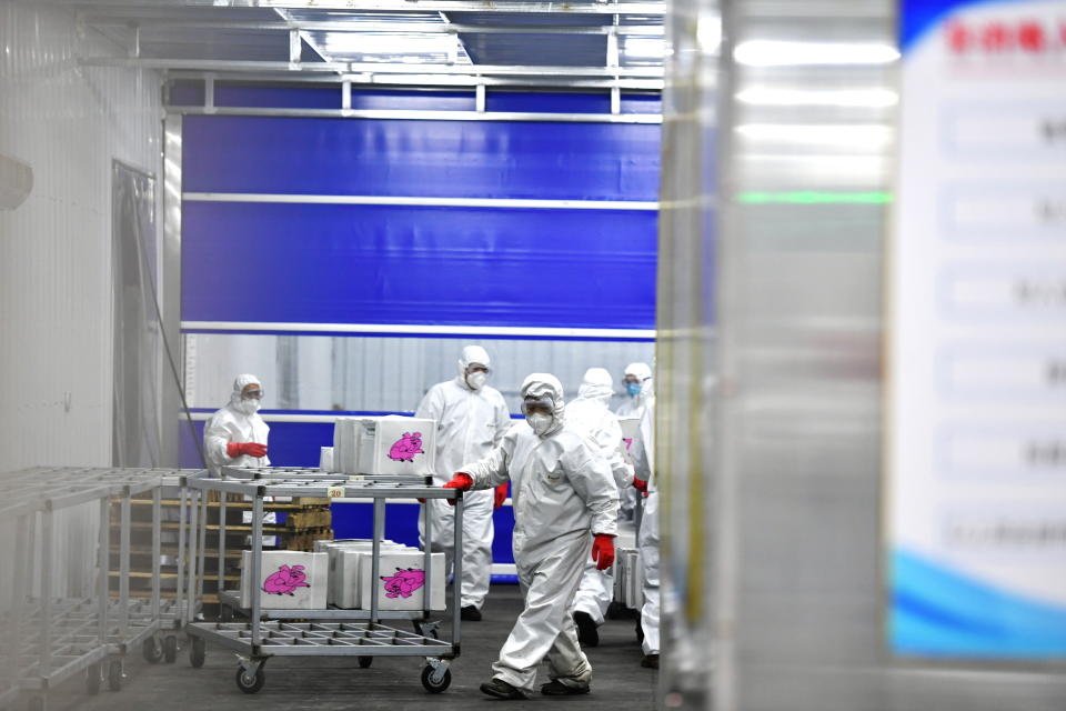 Staff members in protective suits transport goods at a newly built warehouse to storage and disinfect imported cold-chain products as a prevention method to curb the spread of the coronavirus disease (COVID-19), in Changchun, Jilin province, China January 25, 2021. cnsphoto via REUTERS ATTENTION EDITORS - THIS IMAGE WAS PROVIDED BY A THIRD PARTY. CHINA OUT.