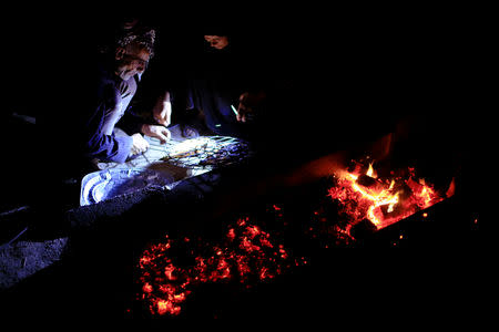 An Iraqi Marsh Arab man with his wife grill a fish at the Chebayesh marsh in Dhi Qar province, Iraq April 13, 2019. Picture taken April 13, 2019. REUTERS/Thaier al-Sudani