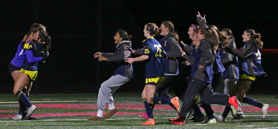 Spencerport players rush to join the celebration with goalkeeper Cate Burns as the final buzzer sounds giving Spencerport the win over Schroeder in their Section V Class AA girls soccer final.