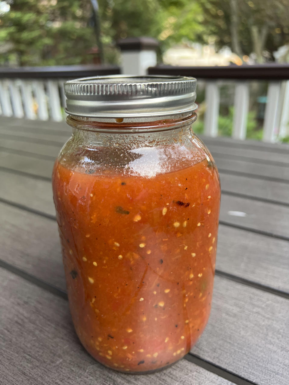 This 2023 image provided by Jessica Damiano shows a jar of cooked tomatoes with basil ready for the freezer on Long Island, New York. (Jessica Damiano via AP)