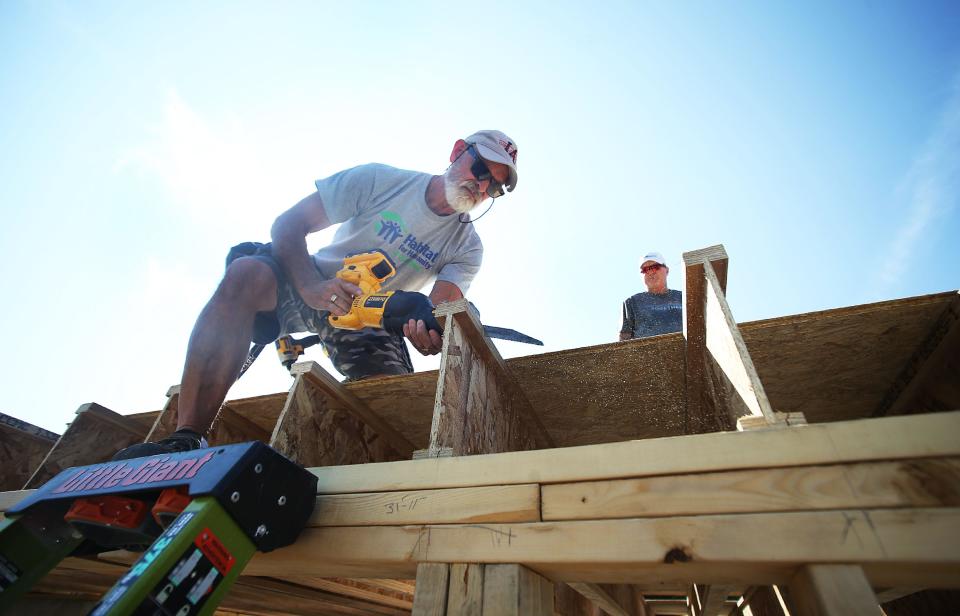 Curt Samson works with volunteer from First Interstate Bank John Jennett work to build three Habitat for Humanity houses at Wilmoth Street on Wednesday, Sept. 13, 2023, in Ames, Iowa.
