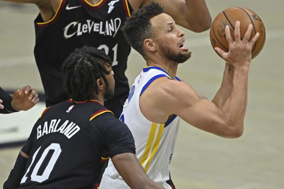 Golden State Warriors' Stephen Curry, right, goes to the basket against Cleveland Cavaliers' Darius Garland (10) in the second half of an NBA basketball game, Thursday, April 15, 2021, in Cleveland. (AP Photo/David Dermer)