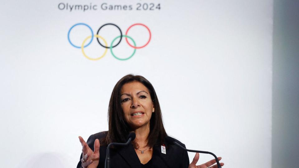 Anne Hidalgo frente al símbolo de los 5 anillos olímpicos