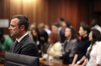 Olympic and Paralympic track star Oscar Pistorius reacts in the dock during his trial for the murder of his girlfriend Reeva Steenkamp, at the North Gauteng High Court in Pretoria, March 10, 2014. Pistorius is on trial for murdering Steenkamp at his suburban Pretoria home on Valentine's Day last year. He says he mistook her for an intruder. REUTERS/Siphiwe Sibeko (SOUTH AFRICA - Tags: CRIME LAW SPORT ATHLETICS)