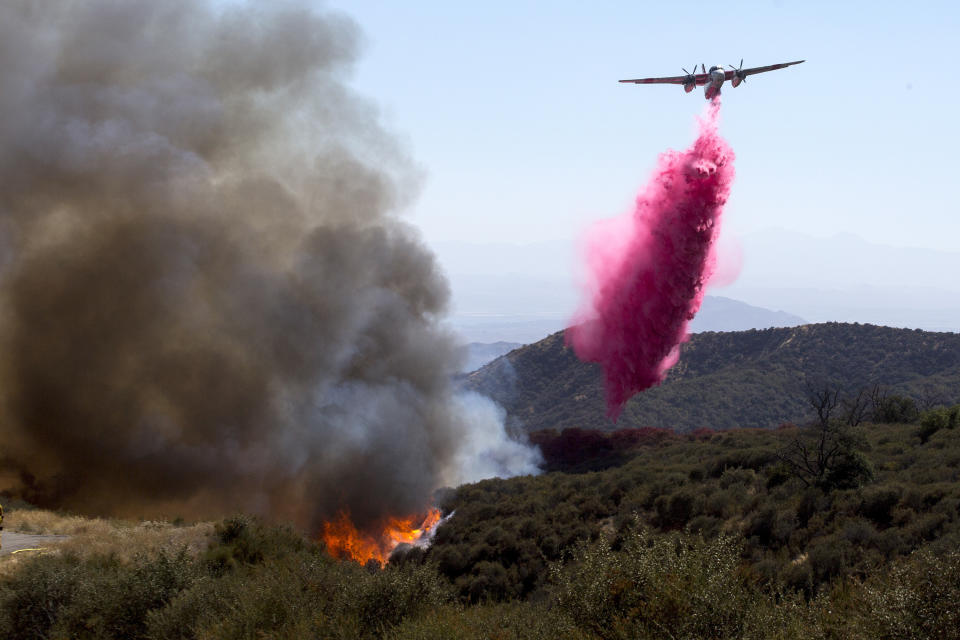 An air tanker drops fire retardant at the Apple Fire in Cherry Valley, Calif., Saturday, Aug. 1, 2020. A wildfire northwest of Palm Springs flared up Saturday afternoon, prompting authorities to issue new evacuation orders as firefighters fought the blaze in triple-degree heat. (AP Photo/Ringo H.W. Chiu)