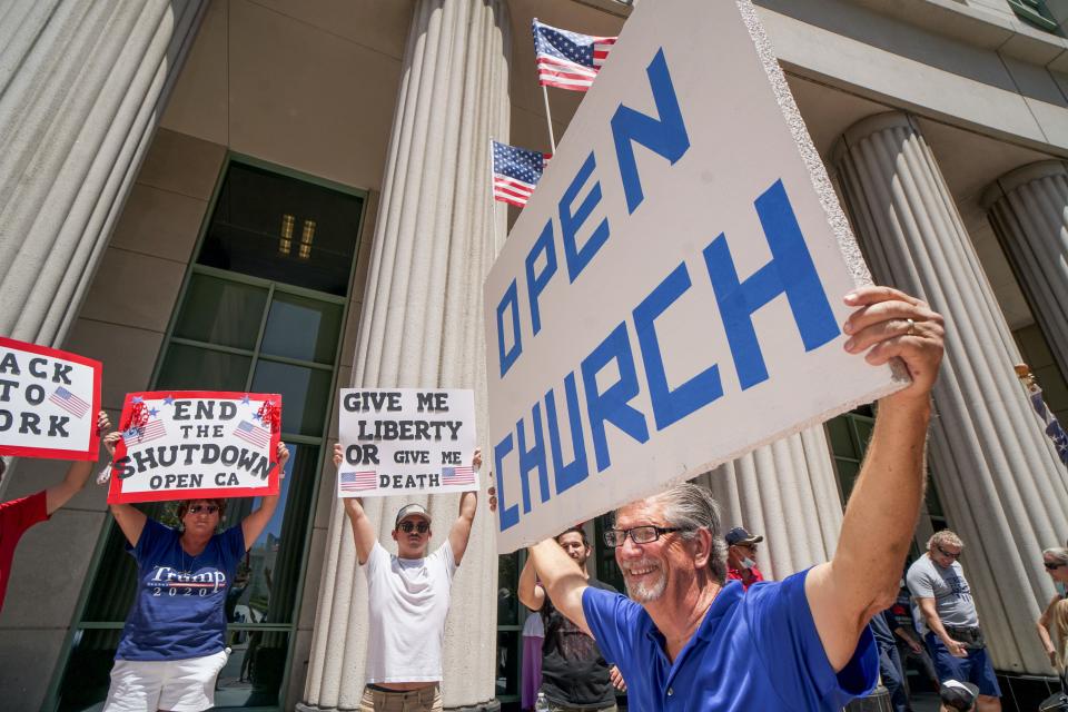 Demonstrators holding signs demanding their church to reopen, protest during a rally to re-open California and against Stay-At-Home directives on May 1, 2020 in San Diego, California. Rallies have been held at several state capitols across the country as protesters express their deep frustration with the stay-at-home orders that are meant to stem the spread of the novel coronavirus. (Sandy Huffaker / AFP via Getty Images)