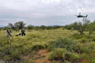 Dos agentes de la Patrulla Fronteriza de EEUU, apoyados por un perro rastreador y un helicóptero Blackhawk, buscan migrantes que ingresaron ilegalmente al país cerca de Sasabe (Arizona) el 8 de septiembre del 2022. (AP Photo/Matt York)