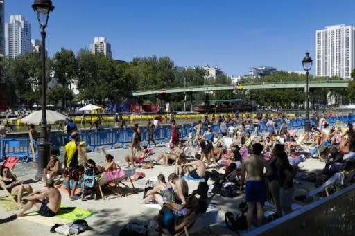 A crowded outdoor swimming pool on a canal in central Paris as people seek relief from the heat