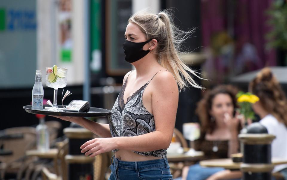 A worker at the Gin and Juice gin bar in Cardiff serves customers - Matthew Horwood/Getty Images