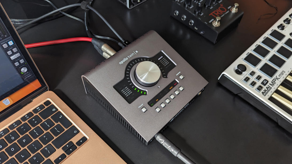  Universal Audio Apollo Twin X on a desk with various recording equipment 