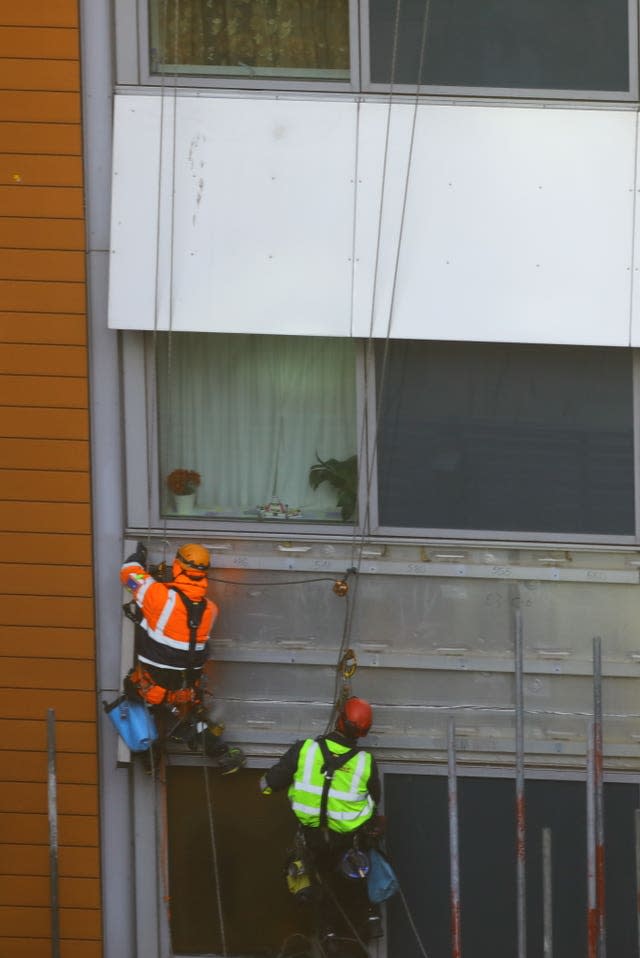 Workmen remove the cladding from the facade of a block of flats in Paddington, north London