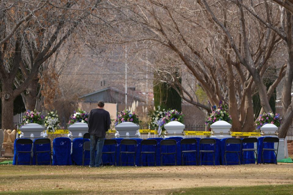 A lone person stand in front of six of the seven caskets for the Haight family on January 13, 2023 in La Verkin, Utah.