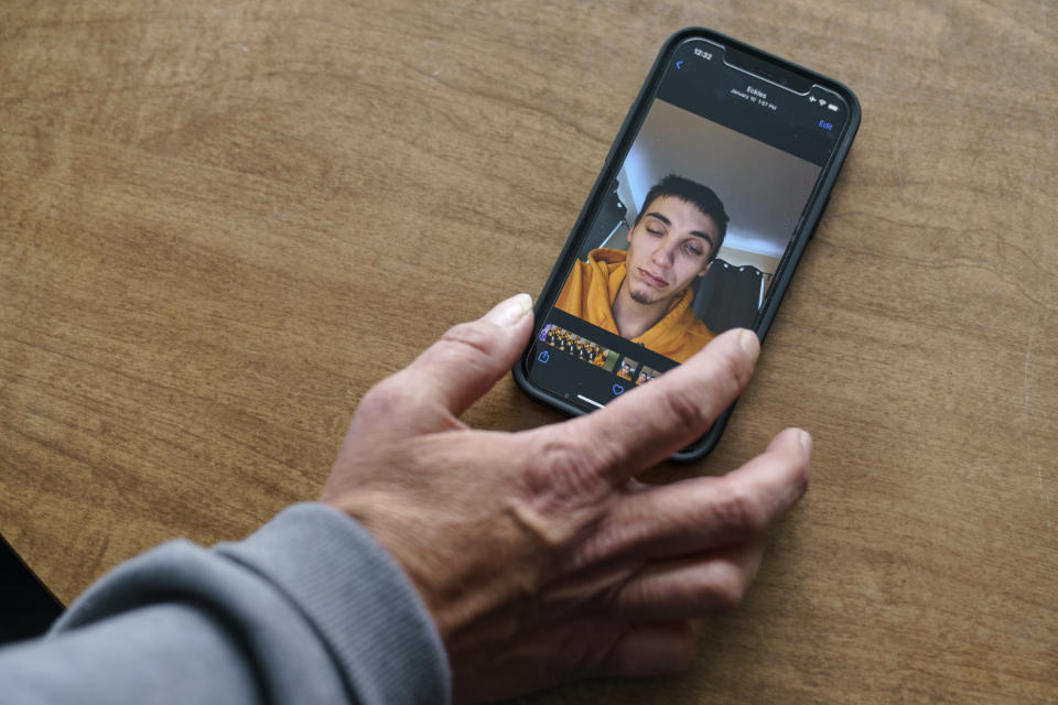 Rachel Taylor scrolls through photos of her son, Kyle Domrese, pictured here the day before he died of a drug overdose in January, as she stands in the home they shared in Bemidji, Minn., Wednesday, Nov. 17, 2021. Domrese once wrote her a letter because he thought his addiction was killing him: "I can't control it. I hope you can forgive me. I'm sorry, I love you, I wanted to spend more time with you." (AP Photo/David Goldman)