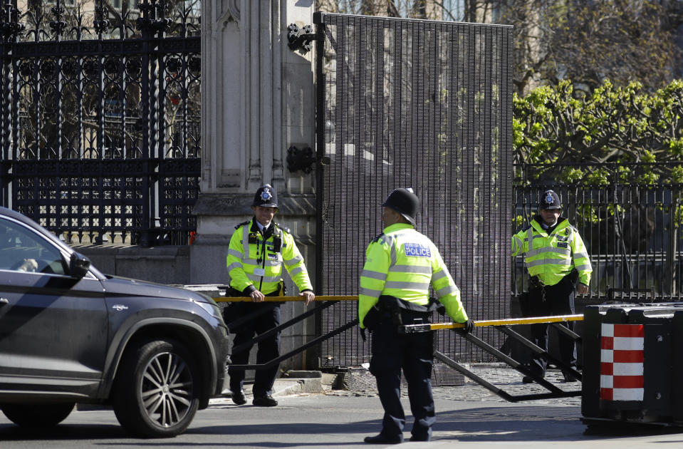 Police officers check a car driving through an entrance to parliament as the country is in lockdown to help curb the spread of coronavirus, in London, Tuesday, April 21, 2020. Britain's Parliament is going back to work, and the political authorities have a message for lawmakers: Stay away. U.K. legislators and most parliamentary staff were sent home in late March as part of a nationwide lockdown to slow the spread of the new coronavirus. With more than 16,500 people dead and criticism growing of the government's response to the pandemic, legislators are returning Tuesday — at least virtually — to grapple with the crisis. (AP Photo/Kirsty Wigglesworth)