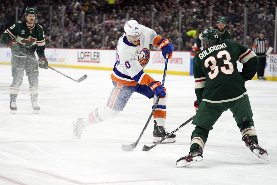 New York Islanders right wing Hudson Fasching, middle, shoots past Minnesota Wild defenseman Alex Goligoski (33) during the second period of an NHL hockey game Tuesday, Feb. 28, 2023, in St. Paul, Minn. (AP Photo/Abbie Parr)