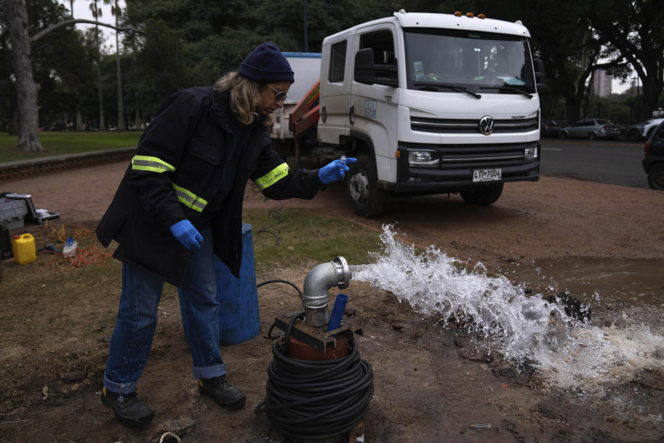 Un empleado de una empresa estatal de saneamiento toma una muestra de agua de un pozo en Montevideo, Uruguay, el miércoles 21 de junio de 2023. (AP Foto/Matilde Campodonico)