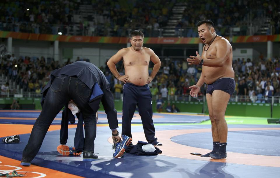 <p>The coach of Mandakhnaran Ganzorig (MGL) of Mongolia takes off his clothes as he protests after the match against Ikhtiyor Navruzov (UZB) of Uzbekistan. (Reuters) </p>