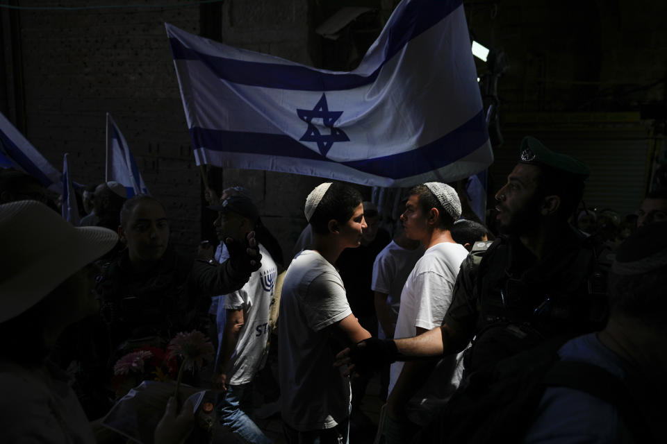 Israelis wave national flags ahead of a march marking Jerusalem Day, an Israeli holiday celebrating the capture of east Jerusalem in the 1967 Mideast war, in Jerusalem's Old City, Thursday, May 18, 2023. (AP Photo/Ohad Zwigenberg)