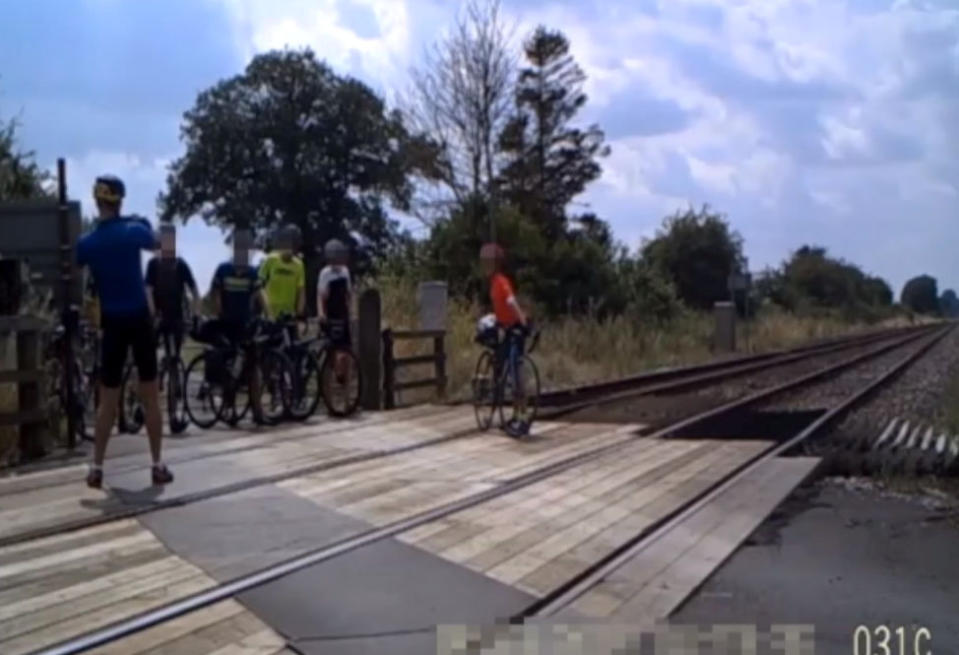 Shocking CCTV footage has been released which shows people risking their lives on level crossings - including a father and his young daughter posing for a photo shoot. The reckless father can be seen taking pictures of the little girl - who appears to be of primary school age - in different directions on the crossing. Their car can be seen in the background with its doors open as the youngster adopts various poses and occasionally looks behind her for approaching trains. Another shocking clip captured on CCTV shows a group of cyclists who dismount their bikes and line up for a group photo on the crossing.