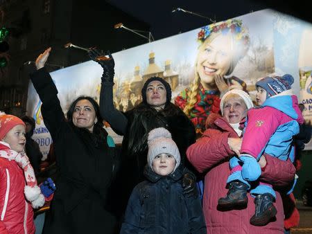 Relatives of new volunteers for the Ukrainian Interior Ministry's Azov battalion wave goodbye as volunteers depart to the frontlines in eastern Ukraine, in central Kiev January 17, 2015. REUTERS/Gleb Garanich