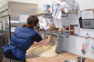 Anna Gosling works with bread dough, which will become about 16 loaves of naturally fermented European style bread at Farmhouse Bakery in Etna on Jan. 26, 2024.