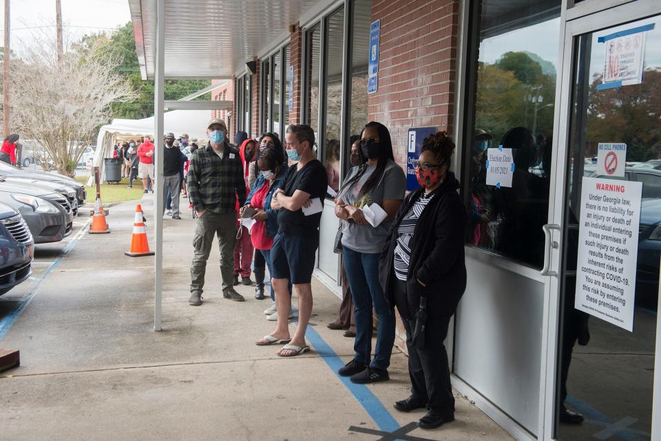 Voters wait in line outside of the Chatham County Board of Elections Office during the first day of early voting during the 2020 election.