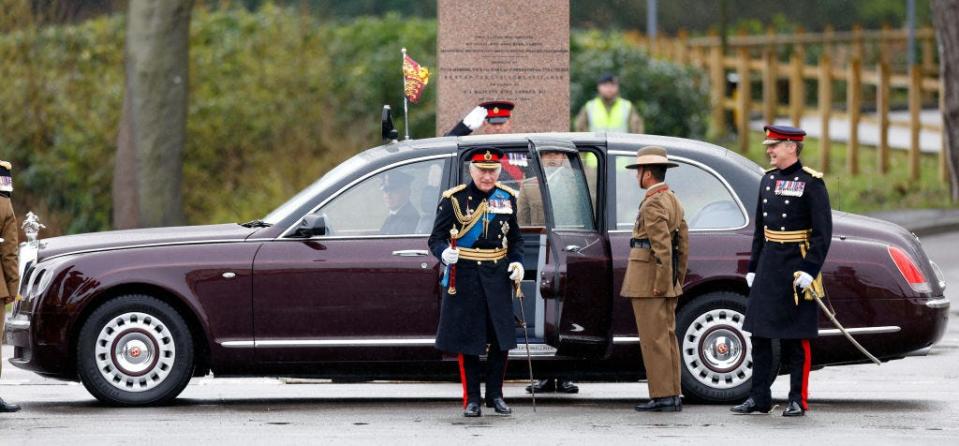 King Charles exits his Bentley State Limousine surrounded by soldiers