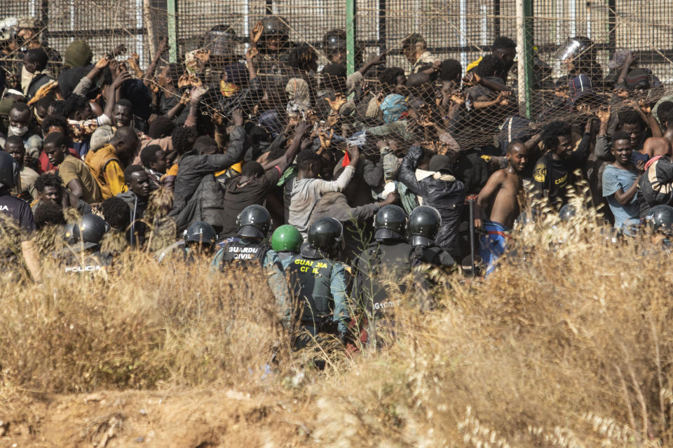 Migrants arrive on Spanish ground after crossing the fences separating the Spanish enclave of Melilla from Morocco in Melilla, Spain, Friday, June 24, 2022. Dozens of migrants stormed the border crossing between Morocco and the Spanish enclave city of Melilla on Friday in what is the first such incursion since Spain and Morocco mended diplomatic relations last month. (AP Photo/Javier Bernardo)