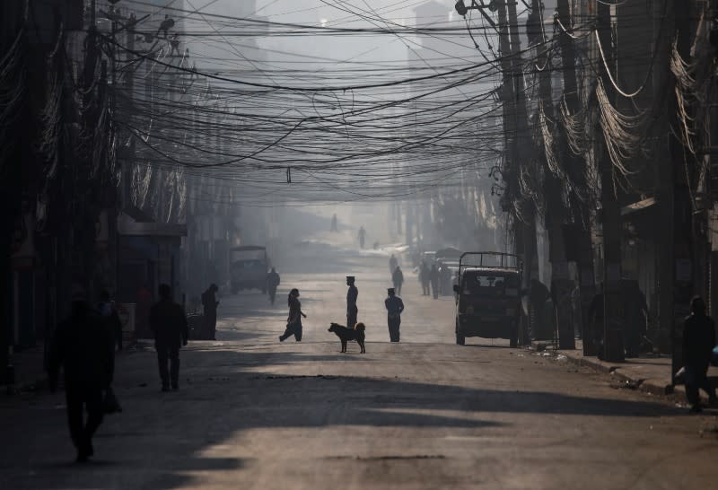 People walk on a deserted road on the fourth day of the lockdown imposed by Nepal's government amid concerns on the spread of the coronavirus disease (COVID-19), in Kathmandu