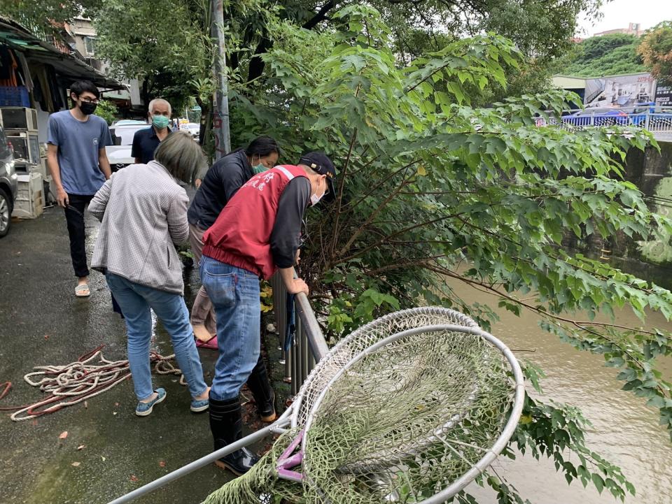 岸上有不少熱心民眾關心狗狗的救援情況。   圖：新北市動保處提供