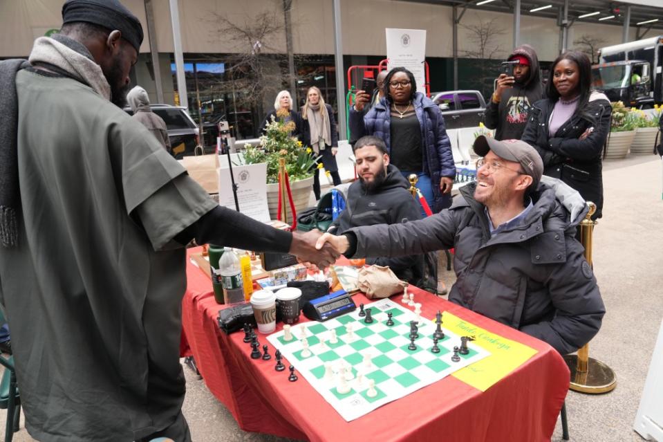 Onakoya is raising money to help chess players in Africa. He even played against Post reporter Jack Morphet (right) James Keivom