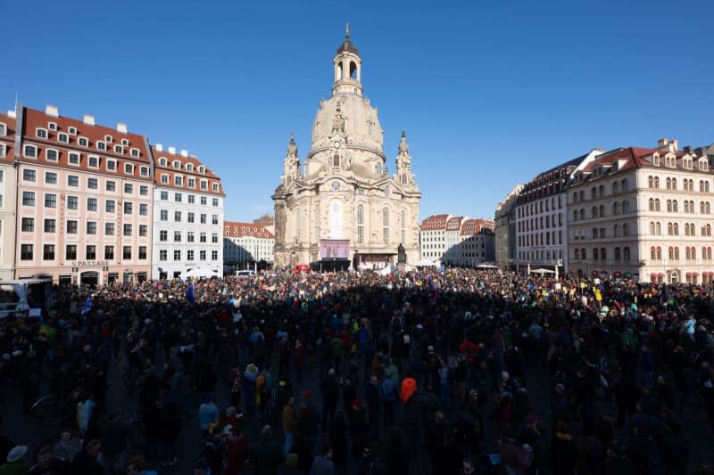 People take part in a large against right-wing extremism stand in front of the Frauenkirche on Neumarkt square in Dresden. Sebastian Kahnert/dpa