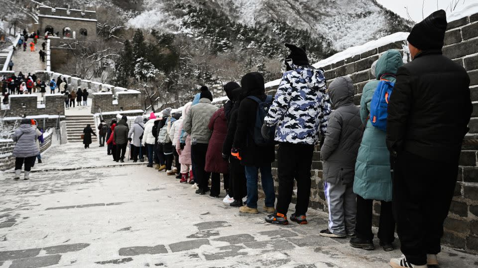 People hold a rope as they climb down an icy section of the Great Wall of China. - Greg Baker/AFP/Getty Images