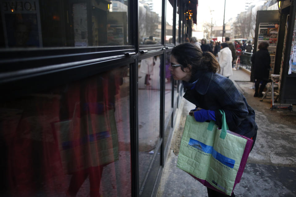 A woman looks inside the restaurant La Rotonde, in Paris, Saturday, jan.18, 2020. The Paris prosecutor's office says it has opened an investigation to determine the causes of the Rotonde fire. (AP Photo/Thibault Camus)