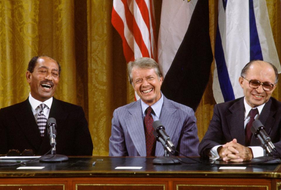 PHOTO: Egyptian President Anwar al-Sadat, US President Jimmy Carter, and Israeli Premier Menachem Begin laugh together during the signing the Camp David Accords in the East Room of the White House, Washington, DC, Sept. 18, 1978. (David Hume Kennerly/Getty Images)