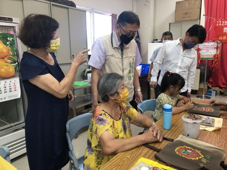 社會局長盧禹璁(中)、西港區長李鴻裕(右)在港東里長方郭秀雲的陪同下，與參加的祖孫話家常。(記者盧萍珊攝)