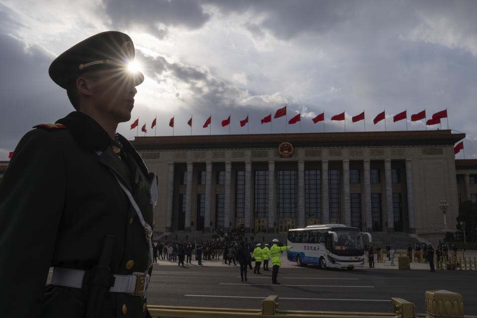 A Chinese paramilitary policeman watch as delegates leave in buses from the Great Hall of the People after the closing session of the National People's Congress in Beijing, Monday, March 11, 2024. (AP Photo/Ng Han Guan)