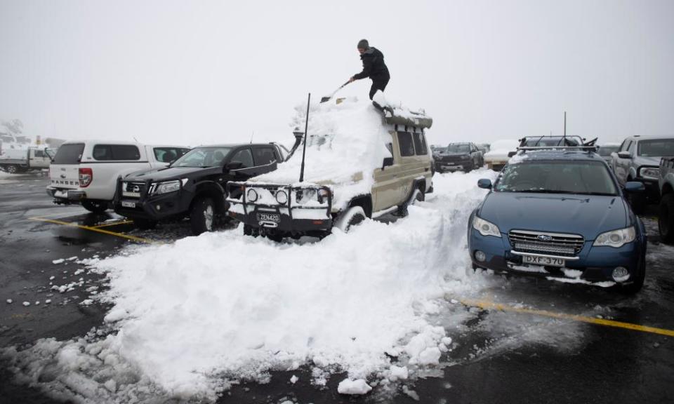 Matthew, a Queenslander from Brisbane on his first visit to the Australian Alps digs out his car staring at the roof