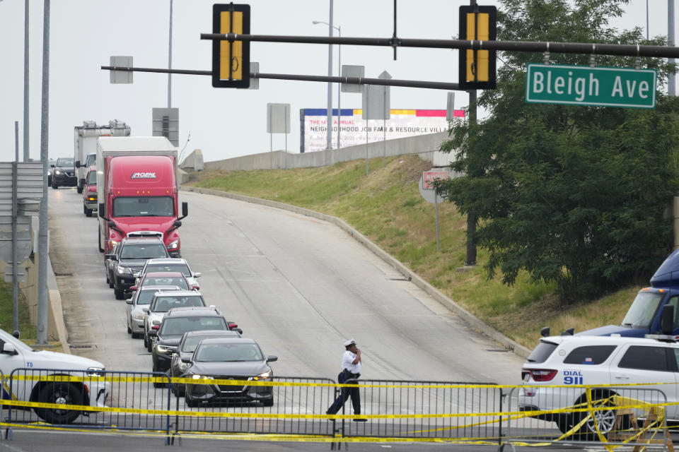 An officer directs traffic detoured from a collapsed elevated section of Interstate 95 in Philadelphia, Monday, June 12, 2023. (AP Photo/Matt Rourke)