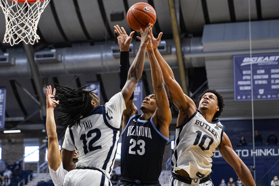 Villanova forward Jermaine Samuels (23) gos up for a rebound with Butler guard Myles Tate (12) and forward Bryce Nze (10) in the first half of an NCAA college basketball game in Indianapolis, Sunday, Feb. 28, 2021. (AP Photo/Michael Conroy)