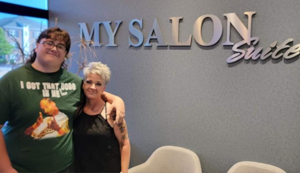 Will Joyner poses with the hairdresser who cuts and helps maintain his mullet – though he proudly points out the curls are natural (Jenny Joyner)