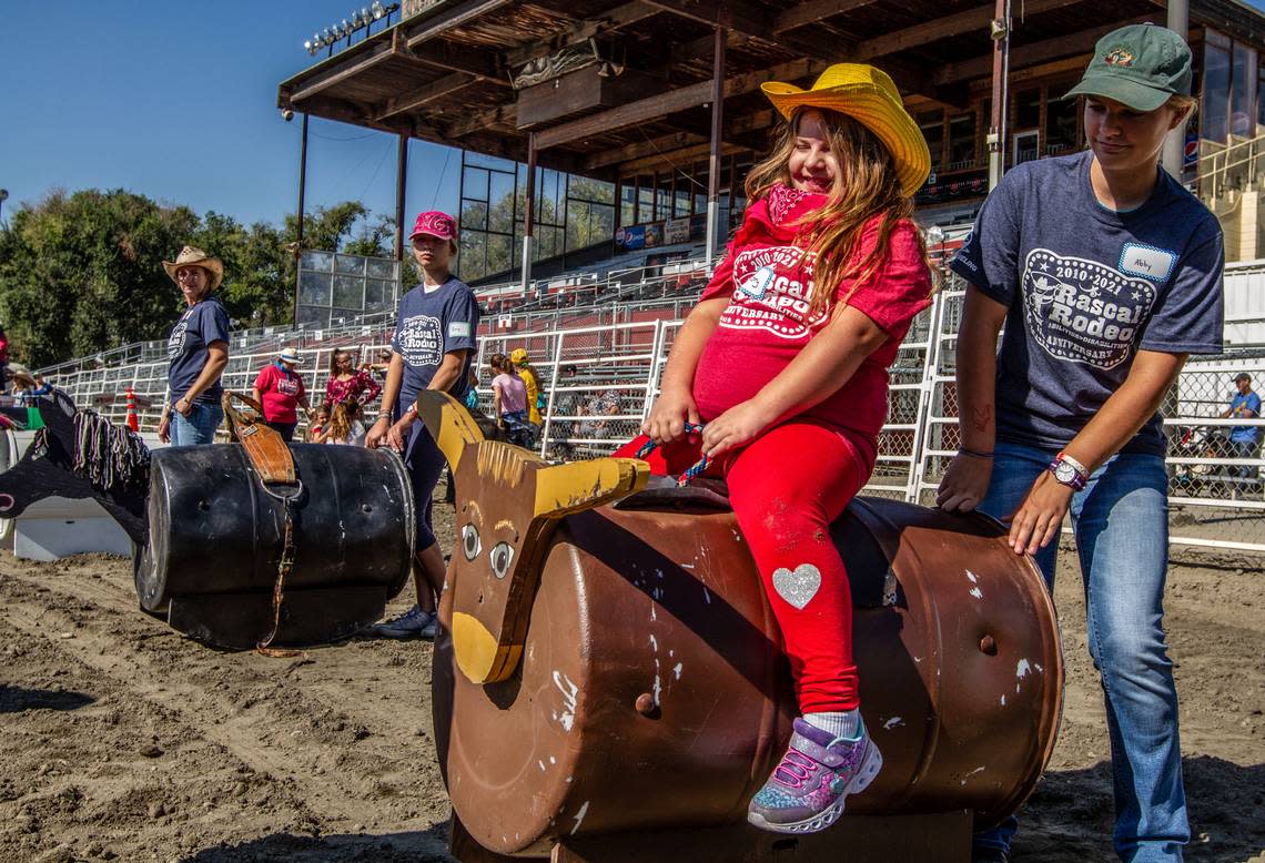 Mallory Burkhart laughs as she rides a bull during the annual Rascal Rodeo at the Benton Franklin Fair & Rodeo in Kennewick.