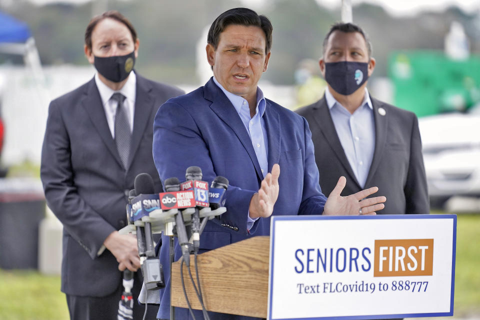 Ron DeSantis stands at a podium that reads: Seniors first, text FLCovid19 to 888777.