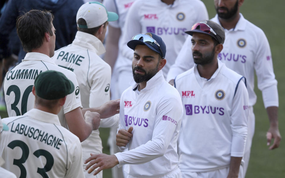 India's Virat Kohli, center, shakes hands with Australian players on the third day of their cricket test match at the Adelaide Oval in Adelaide, Australia, Saturday, Dec. 19, 2020. Australia won the match. (AP Photo/David Mariuz)