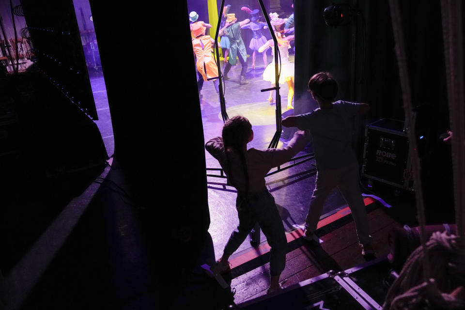 Children dance in the backstage imitating their parents, during the show "Alice in Wonderland" in Pistoia, Italy, Friday, May 6, 2022. A Ukrainian circus troupe is performing a never-ending “Alice in Wonderland” tour of Italy. They are caught in the real-world rabbit hole of having to create joyful performances on stage while their families at home are living through war. The tour of the Theatre Circus Elysium of Kyiv was originally scheduled to end in mid-March. (AP Photo/Alessandra Tarantino)