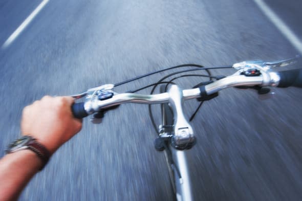 USA, New York City, Hand gripping handlebar of bike