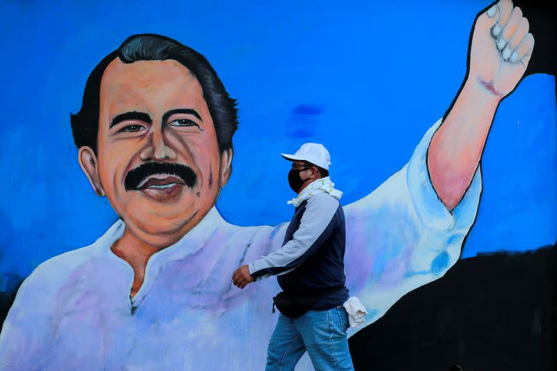 FOTO DE ARCHIVO. Un hombre, con una mascarilla de protección contra la enfermedad del coronavirus (COVID-19), camina junto a un mural que representa al presidente de Nicaragua, Daniel Ortega, en Managua, Nicaragua