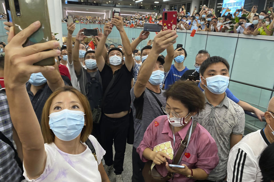 Supporters of Huawei CFO Meng Wanzhou take smartphone photos as they gather at Shenzhen Bao'an International Airport in Shenzhen in southern China's Guangdong Province, Saturday, Sept. 25, 2021. A top executive from global communications giant Huawei Technologies returned to China on Saturday following what amounted to a high-stakes prisoner swap with Canada and the U.S. (AP Photo/Ng Han Guan)