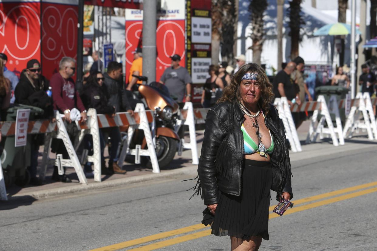 A woman crosses Main Street in Daytona, FL during Bike Week on March 5, 2021. (Sam Thomas/Orlando Sentinel)